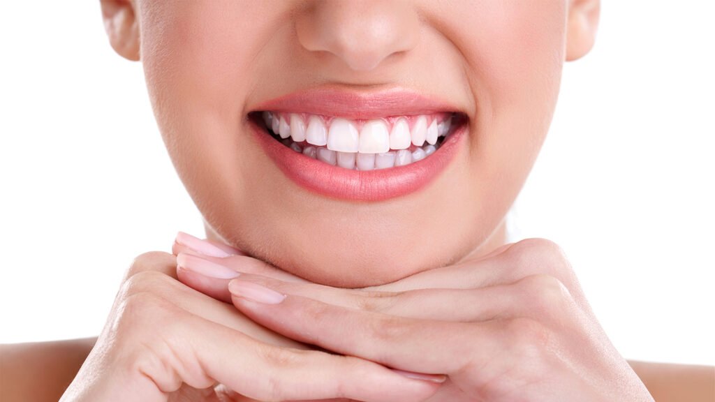 close-up of a woman's mouth and hands under her chin